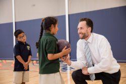 man giving student a basketball